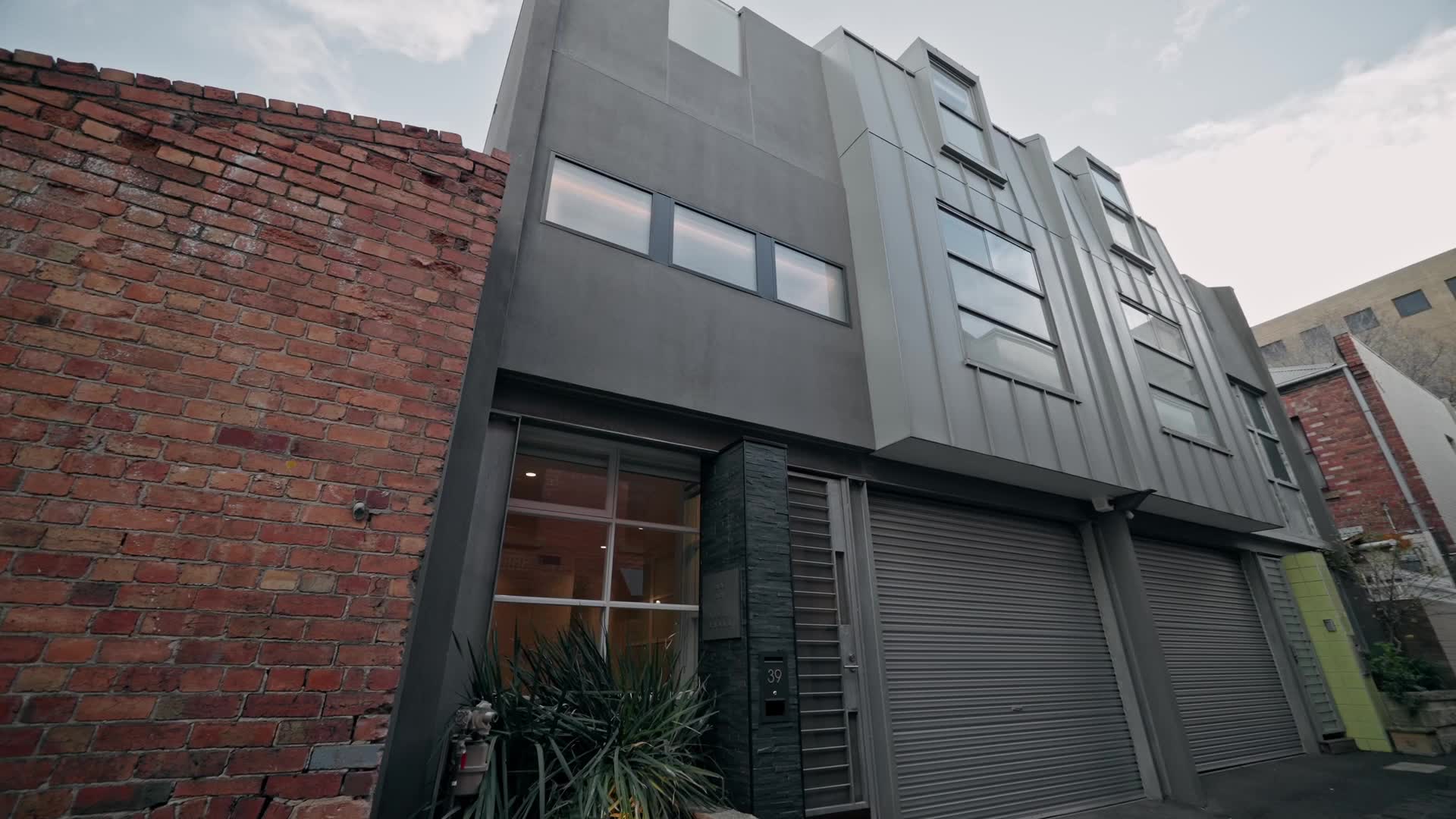 Exterior of the Carlton project by JRG Built — dark cladding beside the original brickwork